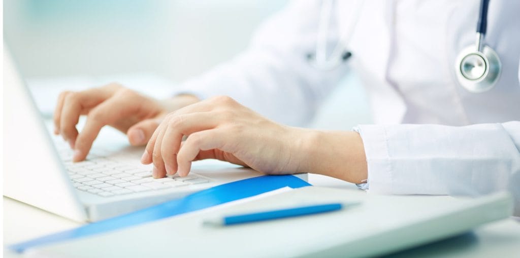 doctor typing on computer